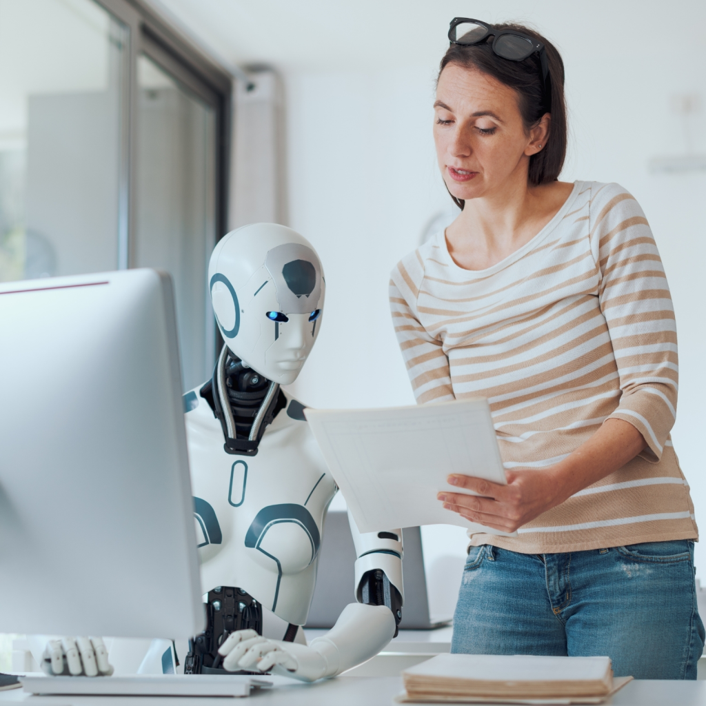Businesswoman collaborating with humanoid robot at office desk, reviewing documents together, symbolizing artificial intelligence, human-robot collaboration, and the future of work.