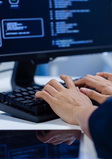 Close-up of a software developer coding at a computer, representing programming, application development, IT solutions and modern digital technology.