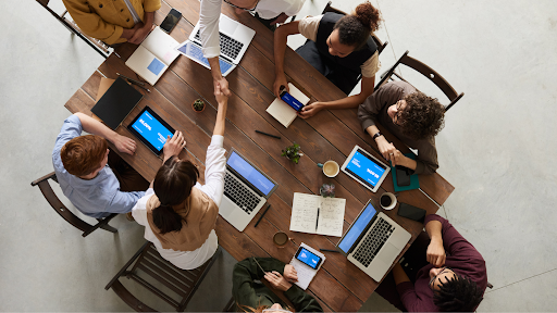 Business team collaborating around a table using laptops and digital devices